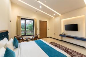 a hotel room with a bed and a tv at Milestone Resort in Thūr