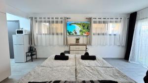 a bedroom with a large bed and a refrigerator at Chloraka Bay Studio in Khlorakas