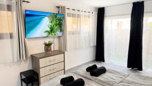 a bedroom with a flat screen tv on the wall at Chloraka Bay Studio in Khlorakas
