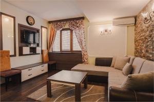 a living room with a couch and a table at Hotel Sumski Feneri in Trnovo