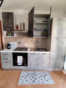 a kitchen with a sink and a stove at Casa Ventaglio Verde in Valledoria