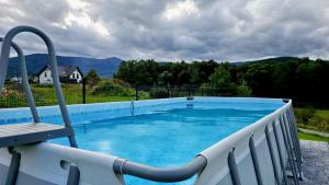 a swimming pool with a chair on a balcony at Zacisze w Karkonoszach in Karpacz