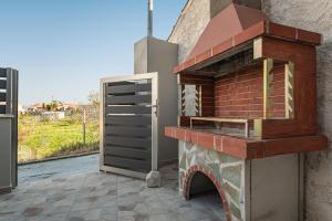 a pizza oven sitting on top of a brick wall at Sirius House in Mytilinioí