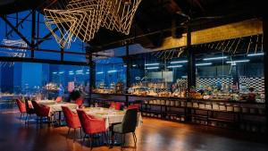 a restaurant with tables and chairs and a bar at Golden Bay Danang in Danang