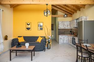a living room with a couch and a kitchen at Sirius House in Mytilinioí