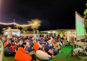 a crowd of people sitting in inflatable chairs watching a presentation at HOMA Phuket Town in Phuket