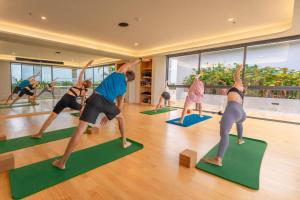 a group of people doing yoga in a room at HOMA Phuket Town in Phuket