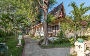 una casa con un árbol delante de ella en Villa Almarik Resort, en Gili Trawangan