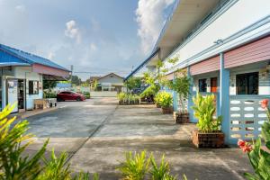 a row of buildings with plants in a parking lot at Chaorua Hotel in Ko Phra Noi