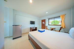 a bedroom with a large white bed and a television at Chaorua Hotel in Ko Phra Noi