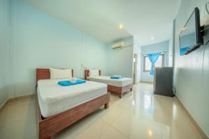 a bedroom with two beds and a tv in it at Chaorua Hotel in Ko Phra Noi