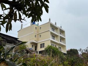 a building on top of a hill with trees at Spring Valley Homestay Rishop in Rishop