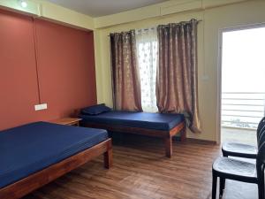 a room with two beds and a window at Spring Valley Homestay Rishop in Rishop