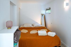 a bedroom with a bed with towels on it at La Petite Sommière in Besançon