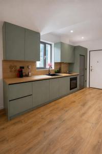a kitchen with gray cabinets and a wooden floor at Dior Apartment in Vlorë +28 photos