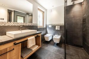 a bathroom with a sink and a toilet at Chalet Esther in Longega +15 photos