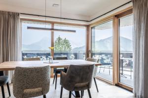 a dining room with a table and chairs and a large window at Chalet Esther in Longega