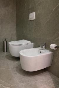 a bathroom with a white sink and a toilet at Dior Apartment in Vlorë