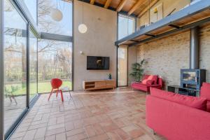 a living room with red furniture and large windows at Flateli Cornellà del Terri in Santa Llogaia del Terri