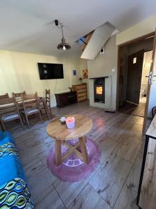 a living room with a table and a fireplace at Domek letniskowy Sarnowo, Skępe in Skępe