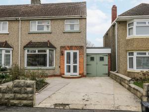 a brick house with a green garage at Lavender Harmony House in Swindon