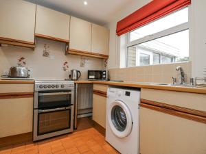 a kitchen with a washing machine and a sink at Lavender Harmony House in Swindon