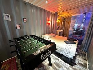 a bedroom with a bed and a pool table at Séjour insolite dans un Container aménagé à Berck avec Borne d'arcade et Babyfoot in Berck-sur-Mer