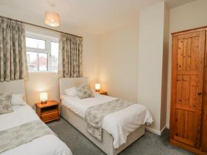 a bedroom with two beds and a window at Lavender Harmony House in Swindon
