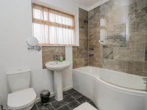a bathroom with a sink and a toilet and a bath tub at Lavender Harmony House in Swindon +8 photos