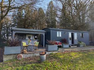 a tiny house in a yard with a patio at Top Farm Shepherds Lodge in Marsham