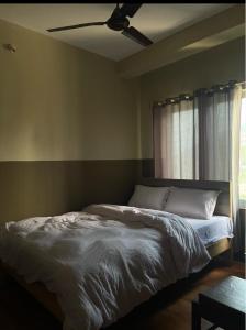 a bed in a bedroom with a ceiling fan at Hotel Lake Heaven in Deorāli