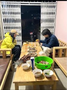 two men sitting at a table with food on it at Hotel Lake Heaven in Deorāli