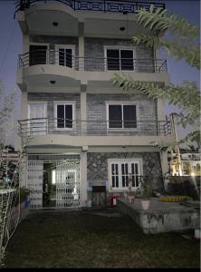 a large white house with a balcony at Hotel Lake Heaven in Deorāli