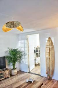 a room with a surfboard on the wall and a mirror at Sotto Terra in Katwijk aan Zee