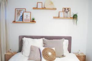 a bed with white pillows and a hat on it at Sotto Terra in Katwijk aan Zee