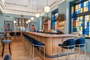 a bar in a restaurant with blue stools at The Maverick By Kasa in Pittsburgh