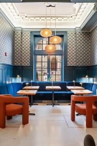 a dining room with tables and blue couches at The Maverick By Kasa in Pittsburgh