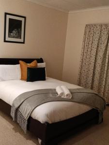 a bedroom with a bed with a towel on it at The Victorian Villa in Chintsa