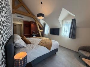 a bedroom with a large bed in a room at Le Fourquet Blaugies - Hôtel & restaurant in Dour