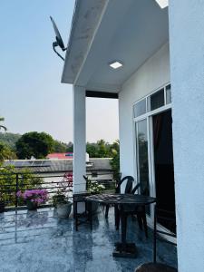 a patio with a table and chairs on a balcony at 22 apartments in Kalapaluwawa