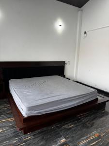 a bed in a room with a white mattress at 22 apartments in Kalapaluwawa
