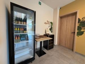 a refrigerator filled with lots of drinks next to a table at Le Fourquet Blaugies - Hôtel & restaurant in Dour