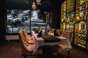 a dining room with a long table and a large window at Hotelli Suomutunturi in Suomutunturi