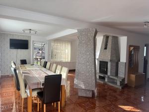 a dining room with a table and a fireplace at Casa Flamingo in Sovata
