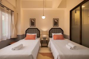 two beds sitting next to each other in a room at Chinoir Boutique Phuket Town in Phuket