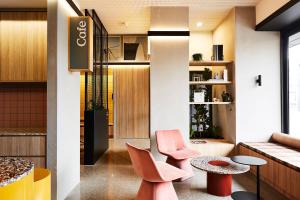 a room with two pink chairs and a table at Urban Rest Lanbruk in Melbourne