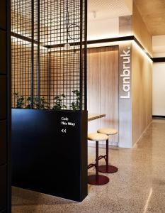 a lobby with a counter and a stool and a wall at Urban Rest Lanbruk in Melbourne