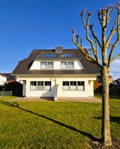 a white house with a black roof at Strandstr_ in Zingst