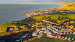 an aerial view of a village on a hill next to the water at Sunset Bay Aberaeron in Aberaeron +2 photos