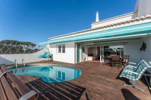 a house with a swimming pool and a patio at Casa Mimosa by Algarve Holidays in Vale do Lobo
